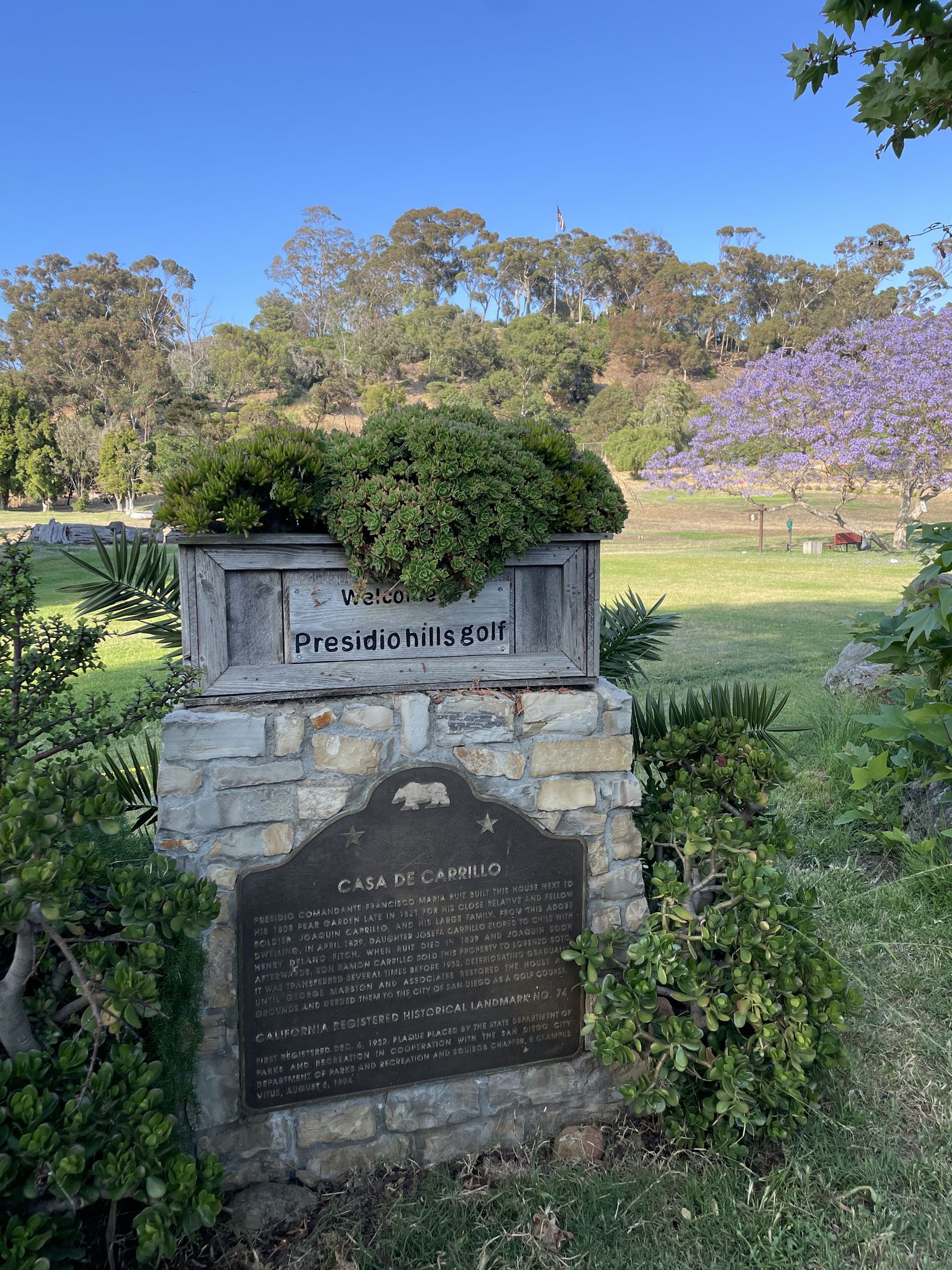 The stone Presidio Hills welcome sign with the Casa de Carrillo landmark plaque